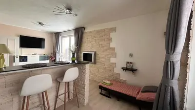 a living room with a bar and two white stools at Bastien Studio near Airport in Prague