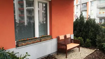 a bench sitting in front of a window with flowers at Bastien Studio near Airport in Prague