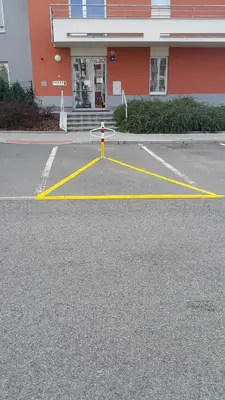 a parking lot with yellow lines in front of a building at Bastien Studio near Airport in Prague