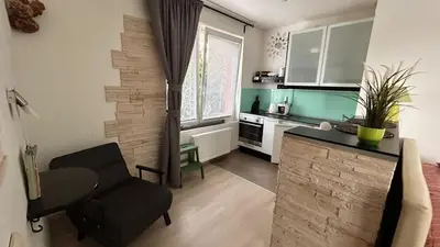 a kitchen with a table and a chair in a room at Bastien Studio near Airport in Prague