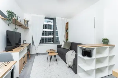 a living room with a couch and a tv at Rentero MyMozart Apartments Prague in Prague