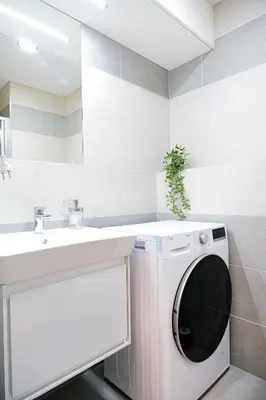 a bathroom with a washing machine and a sink at Rentero MyMozart Apartments Prague in Prague