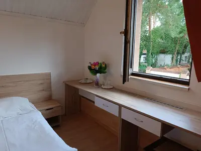 a bedroom with a bed and a window with flowers at Ardilla in Lhota