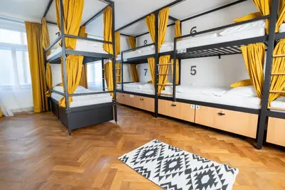 a kitchen with a wooden table and yellow chairs at White Wolf House Hostel & Apartments in Prague