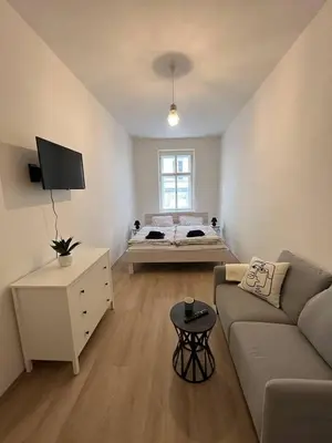 a living room with a couch and a bed at Apartmány Soukenická in Prague