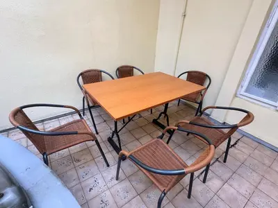 a wooden table and chairs sitting next to a wall at Apartmány Soukenická in Prague