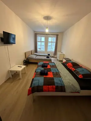 a bedroom with two beds and a television in it at Apartmány Soukenická in Prague