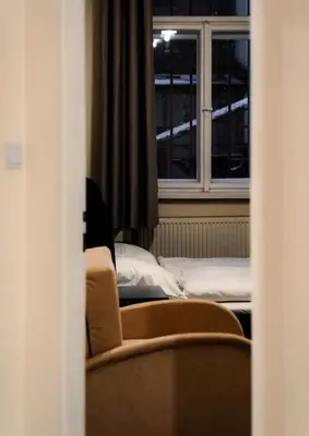 a room with a bed and a chair and a window at Apart Comfort in Prague