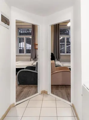 a living room with two beds and a mirror at Apart Comfort in Prague