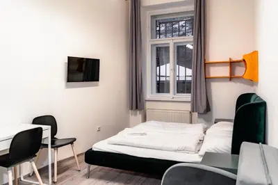 a bedroom with a bed and a table and a window at Apart Comfort in Prague