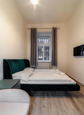 a bedroom with a bed and a couch and a window at Apart Comfort in Prague