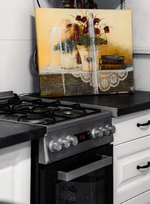 a kitchen with a stove and a painting on the wall at Apart Comfort in Prague