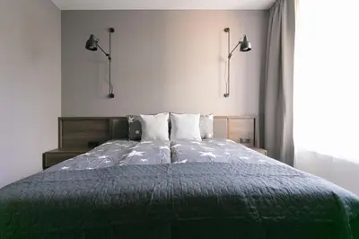 a bedroom with a green bed with two pillows at LUONG Europe Apartments in Prague
