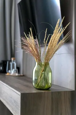 a green vase with grass in it on a counter at LUONG Europe Apartments in Prague