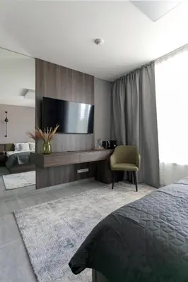 a bedroom with a tv and a bed and a chair at LUONG Europe Apartments in Prague