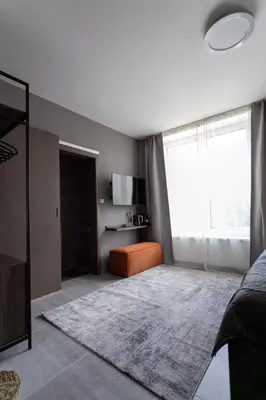 a bedroom with a bed and a large window at LUONG Europe Apartments in Prague