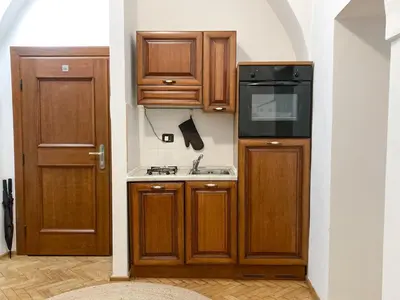 a small kitchen with wooden cabinets and a sink at Best Price & Location - Historic Square Residency in Prague