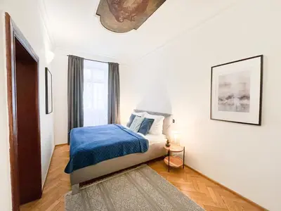 a bedroom with a bed with a blue blanket at Best Price & Location - Historic Square Residency in Prague
