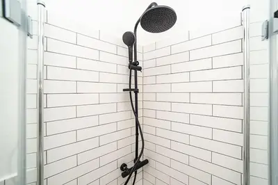 a shower in a white brick wall with a shower head at Cozy apartment in hipster area in Prague