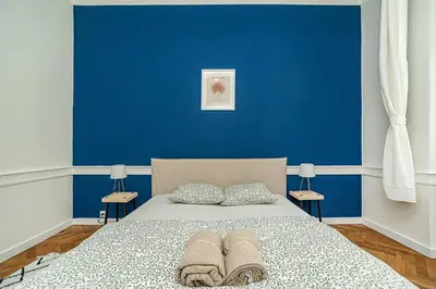 a blue bedroom with a bed with towels on it at Cozy apartment in hipster area in Prague