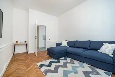 a living room with a blue couch and a rug at Cozy apartment in hipster area in Prague