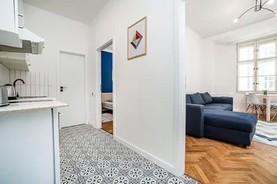 a living room with a blue couch and a kitchen at Cozy apartment in hipster area in Prague