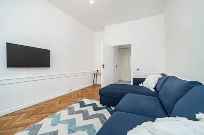 a living room with a blue couch and a flat screen tv at Cozy apartment in hipster area in Prague