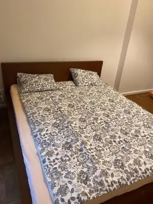 a bed with a black and white comforter and pillows at Large 3 bedroom family apartment close to the river in Prague