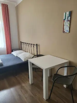 a room with a bed and a white table and chairs at Pension Sunflower in Prague