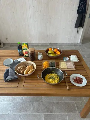 a wooden table with bowls of food on it at Zámek Jenišovice in Býkev