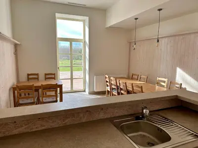 a kitchen and dining room with a sink and a table at Zámek Jenišovice in Býkev
