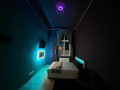 a dark room with a bed with a purple ceiling at SPA SPA Apartments Vyšehrad in Prague