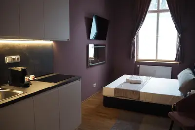 a bedroom with a bed and a kitchen with a sink at SPA SPA Apartments Vyšehrad in Prague
