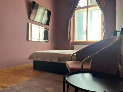 a room with a bed and a table and a window at SPA SPA Apartments Vyšehrad in Prague