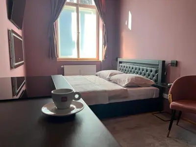 a bedroom with a bed and a table with a cup on it at SPA SPA Apartments Vyšehrad in Prague