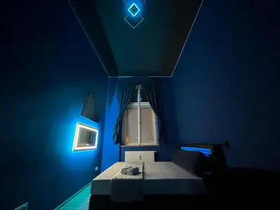 a blue room with a bed and a window at SPA SPA Apartments Vyšehrad in Prague