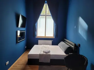 a blue bedroom with a bed with a window at SPA SPA Apartments Vyšehrad in Prague