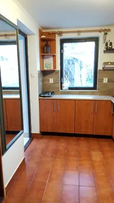 a kitchen with wooden cabinets and a window at Dům V Podzámčí in Mělník