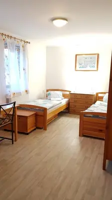 a bedroom with two beds and a table in it at Dům V Podzámčí in Mělník