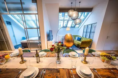 a dining room table with plates and flowers on it at 5BR+2Bath Old Town Industrial Penthouse, A/C in Prague