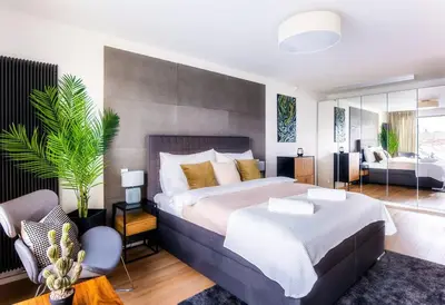 a bedroom with a large bed and a living room at 5BR+2Bath Old Town Industrial Penthouse, A/C in Prague
