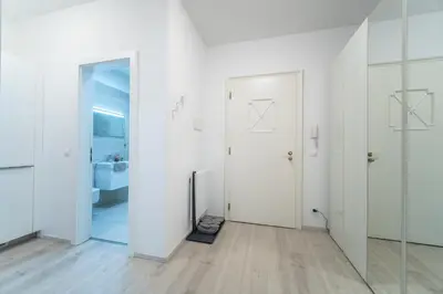 a white room with two doors and a bathroom at A Prague Apartment - Old Town in Prague