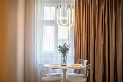 a table with a vase of flowers on it in front of a window at A Prague Apartment - Old Town in Prague