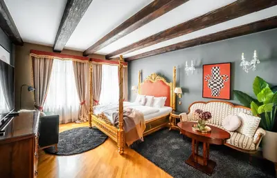 a bedroom with a bed and a couch and a tv at Nosticova Heritage in Prague