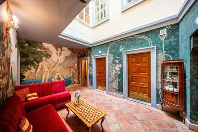 a living room with a red couch and a mural at Nosticova Heritage in Prague