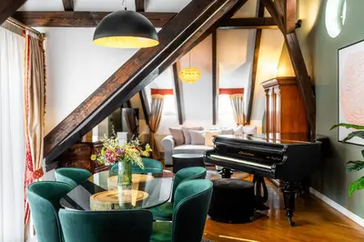 a living room with a piano and green chairs at Nosticova Heritage in Prague