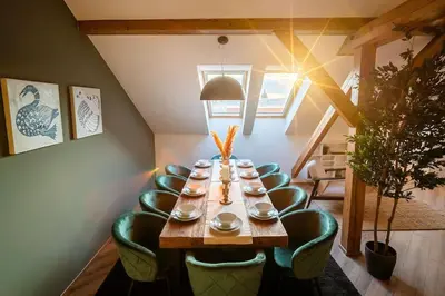 a long table with green chairs in a room at 6BR Castle V!EWS A/C luxury Dolce Vita apartment in Prague