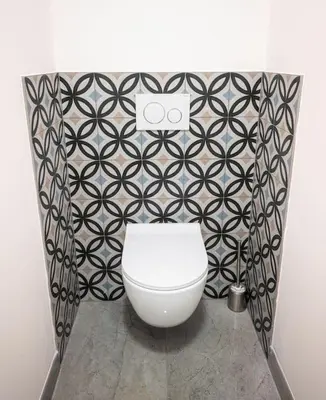 a bathroom with a toilet and a black and white patterned wall at 6BR Castle V!EWS A/C luxury Dolce Vita apartment in Prague