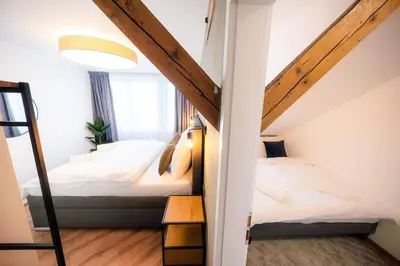 a attic bedroom with two beds and a window at 6BR Castle V!EWS A/C luxury Dolce Vita apartment in Prague