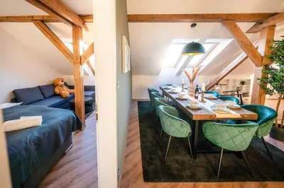 a dining room and living room with a table and a couch at 6BR Castle V!EWS A/C luxury Dolce Vita apartment in Prague